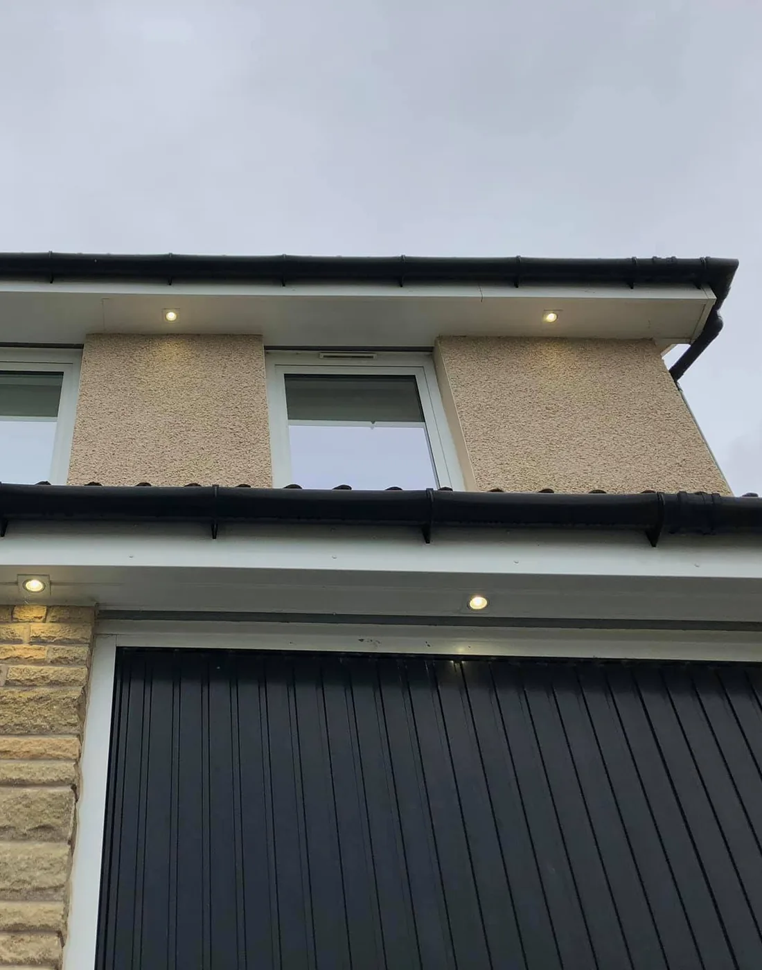 Soffit downlights above a garage door at dusk, Bishopton